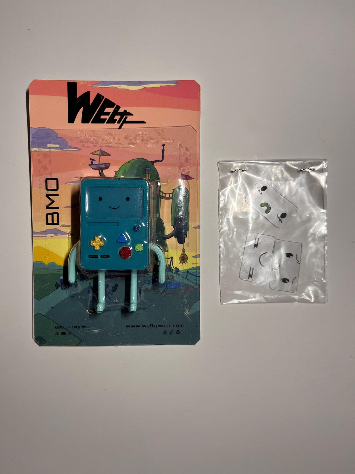 Referans görsel — BMO Işıklı Figür ve Anahtarlık. Wefty Design'in kendi baskısının fotoğrafı değildir.